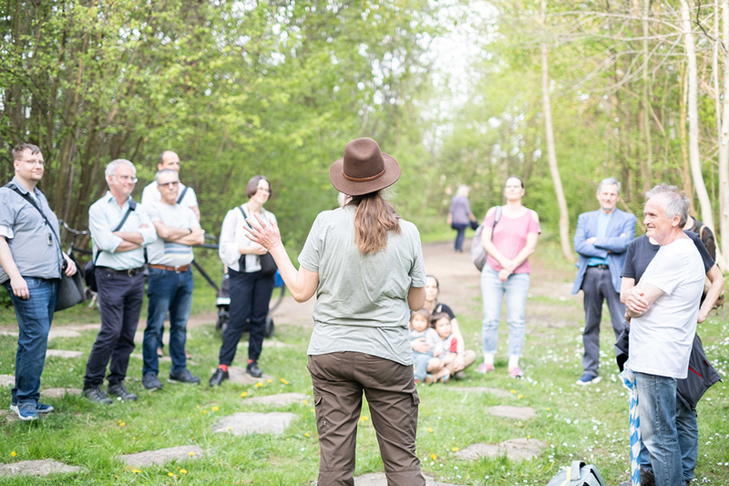Eine Frau erklärt einer Gruppe von Menschen die zu hörenden Vogelstimmen im Rockinger Wald.